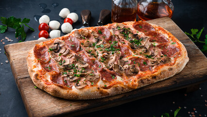 Italian cuisine pinza or pizza with sausage, ham, mushrooms, cheese and herbs.