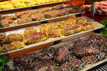 Meat department, showcase with variety of meat in different cuts. Inside an supermarket. Different types of fresh meat arranged in an orderly manner.
