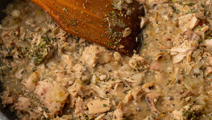 pan with food. wooden spoon, stirring the meat and vegetables.