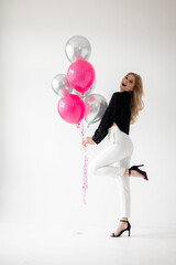 Smiling blonde woman with balloons isolated on white. Girl with braces. Orthodontics treatment.