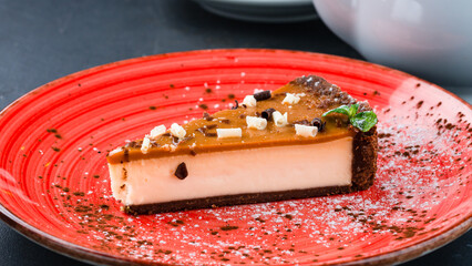 Piece of cheesecake with caramel, chocolate and mint.