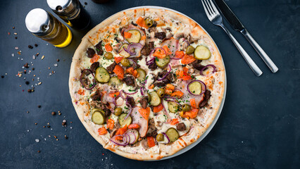 Italian pizza with mushrooms, pickled cucumbers, olives, tomatoes, onions, cheese and herbs.