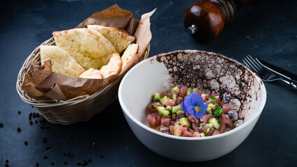 Fresh tuna tartare with avocado, red onion, microgreens and flatbread.