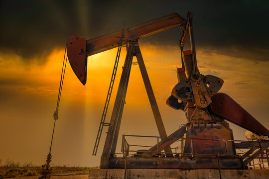 Hard working Pump Jack sunset in Midland Texas Permian Oil fields