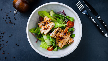 Green salad with squid, cucumbers, lettuce, cherry tomatoes, arugula, beets and red onion.