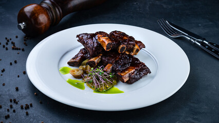 Fried beef ribs with pickled cucumbers, microgreens and sauce.