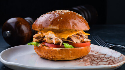 American food chicken burger with tomato, cheddar cheese and lettuce.