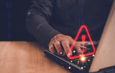 Businessman using computer laptop with triangle caution warning sign for notification error and...