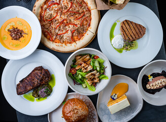 Banquet set pizza, beef and pork steak with salad, pumpkin cream soup, carrot cake and pate.