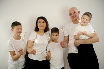 happy family mother, father and children celebrate Christmas and new year, light sparklers middle aged couple enjoying time with three children over white background High quality photo 