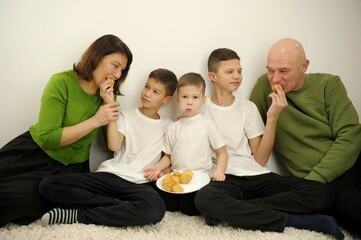 family eating eclairs A large and friendly family has lunch at home. High quality 4k footage