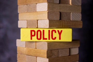 Concept word 'policies' on wooden cubes between pages of a book on a beautiful wooden table.