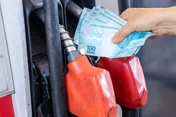 Brazil, gas station woman holding a handful of money, concept, gas station prices, refueling cars,...