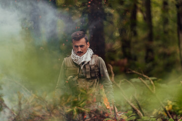 Obraz premium A modern warfare soldier on war duty in dense and dangerous forest areas. Dangerous military rescue operations