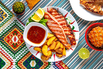 Traditional mexican food. Grilled salmon with potato wedges. Colorful Food Table Celebration Delicious Party Meal Concept. 