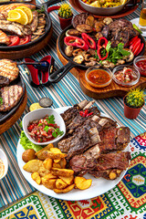 Traditional mexican food. Assorted lamb, calf and pig ribs and baked potatoes. Colorful Food Table Celebration Delicious Party Meal Concept. 
