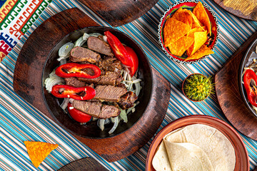 Traditional mexican food. Frying pan with hot lamb and beef fajitas. Colorful Food Table Celebration Delicious Party Meal Concept. 