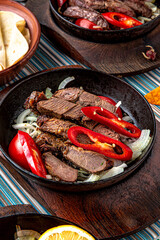 Traditional mexican food. Frying pan with hot lamb and beef fajitas. Colorful Food Table Celebration Delicious Party Meal Concept. 