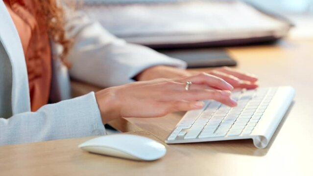 Closeup of the hands of a business woman typing on computer keyboard in an office using bluetooth. Entrepreneur working on a computer, researching, compiling reports and planning in a startup company