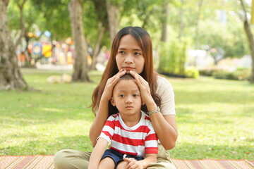 Mother and baby playing in the park happily.