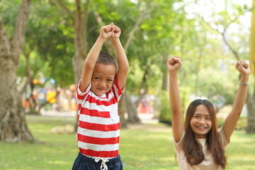 Obraz premium Mother and baby playing in the park happily.