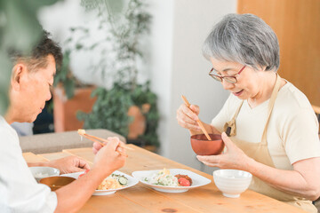 家で食事をする高齢者夫婦(和食)
