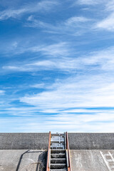 Concrete embankment and stairs with rusty railings and sky.