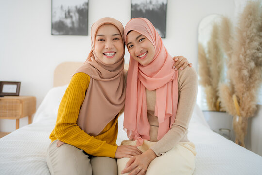 Young Beauty Muslim woman talking and laughing on the bed. Happy two friends true friendship.