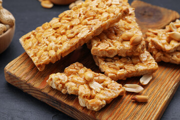 Delicious peanut bars (kozinaki) and ingredients on black table, closeup