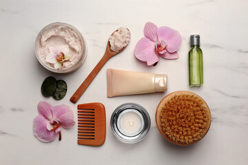 Obraz na płótnie Canvas Flat lay composition with different spa products and flowers on white marble table