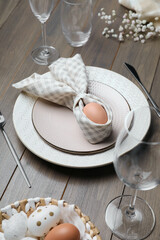 Festive table setting with bunny ears made of egg and napkin. Easter celebration
