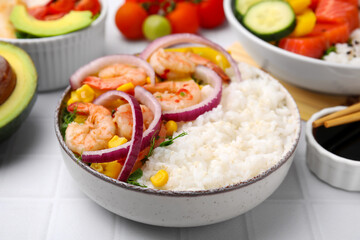 Delicious poke bowl with shrimps, rice and vegetables on white table, closeup