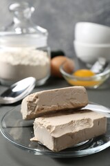 Compressed yeast, eggs and flour on grey wooden table