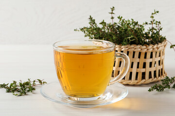 Aromatic herbal tea with thyme on white wooden table
