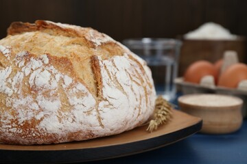 Freshly baked bread on blue wooden table, closeup. Space for text