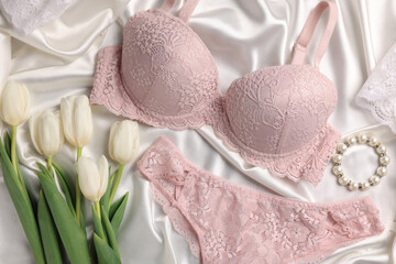 Flat lay composition with pink women's underwear and tulips on white fabric - obrazy, fototapety, plakaty