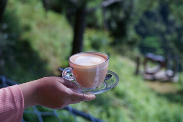 Secangkir kopi latte dengan latar belakang alam