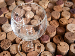 Empty wine glass on used wine cork background