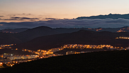 View of sunset with clouds over a town in a mountainside, Las Palmas de Gran Canaria, Spain