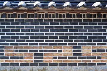 Stone pattern wall and tile roof of Korean traditional house.  oriental stone wall background.
