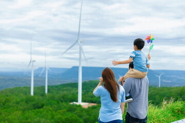 Progressive happy family enjoying their time at wind farm for green energy production concept. Wind...
