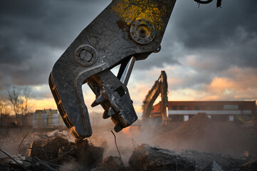 Metal crusher on excavator rigging destroys armored concrete