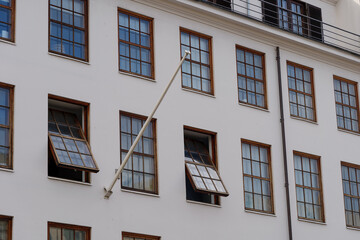 Low angle exterior view, typical facade with repeating grid pattern inside rectangular windows of old modern building in Copenhagen, Denmark. 
