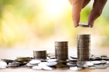 Saving money concept preset by Male hand putting money coin stack growing business, and financial...