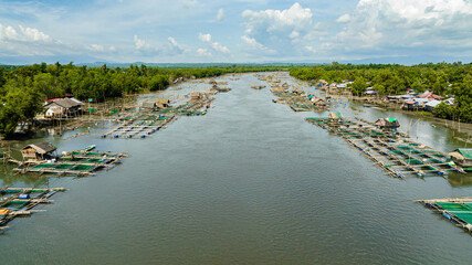 Aerial view of fish farm on the river and a village with fishermen. Hinigaran River. Negros, Philippines © Alex Traveler