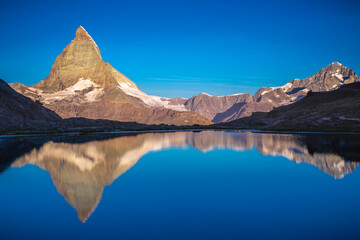 Fototapeta na wymiar Reflection of the Matterhorn on blue lake at sunrise, Swiss Alps, Zermatt