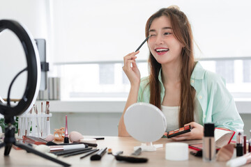 Beauty blogger concept, Young woman is applying eyeshadow on the eyelids to review product on Vlog