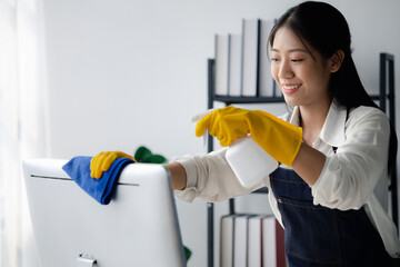 Person cleaning room, cleaning worker is using cloth to wipe computer screen in company office room. Cleaning staff. Concept of cleanliness in the organization.