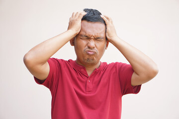 Asian man has a headache stress from work.