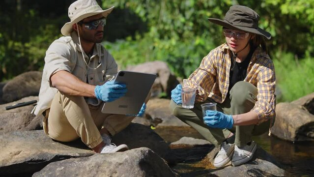 water day and World environment day concept.Environmental engineers inspect water quality at natural water sources and record data on tablet.Man engineer and Woman scientist and environmental issues